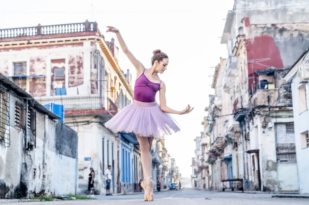 Ballerina tanzt während eines Fotoworkshops auf einer Straße in Havanna zwischen den historischen Gebäuden Kubas.