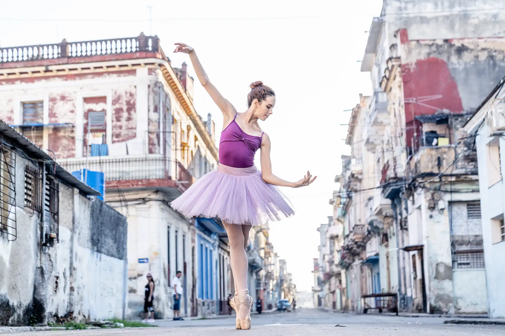 Ballerina tanzt während eines Fotoworkshops auf einer Straße in Havanna zwischen den historischen Gebäuden Kubas.